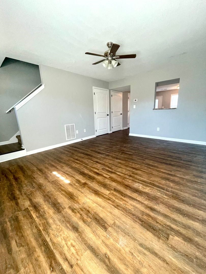 a living room with a ceiling fan and wood floors