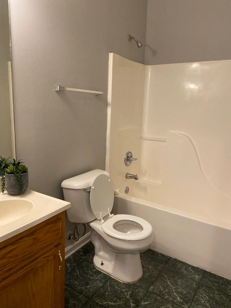 a bathroom with a toilet and a tub and a sink