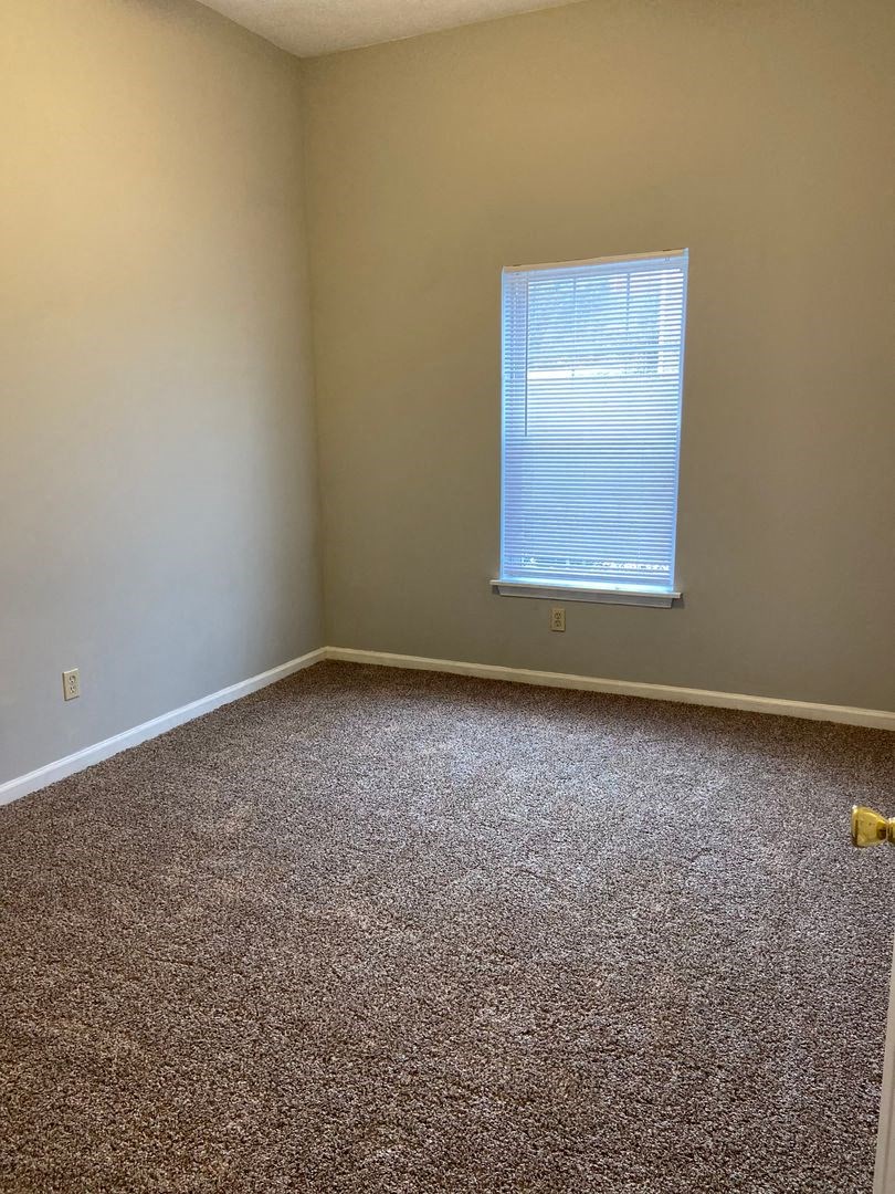 a room with a carpeted floor and a window