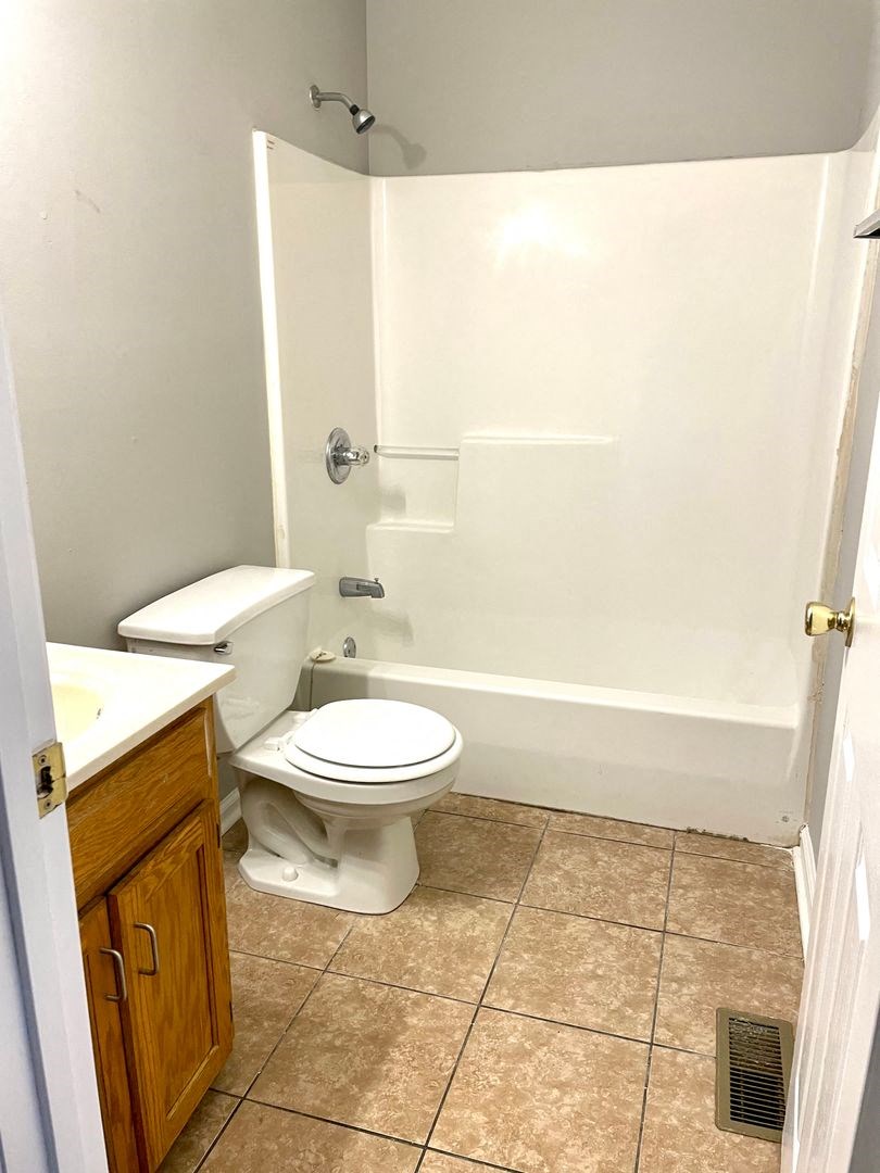 a bathroom with a toilet and a tub and a sink