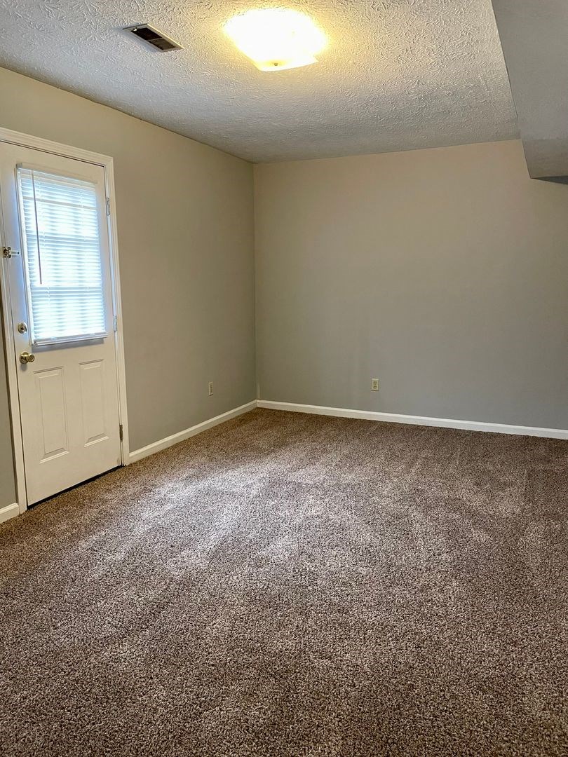 a room with a carpeted floor and a white door
