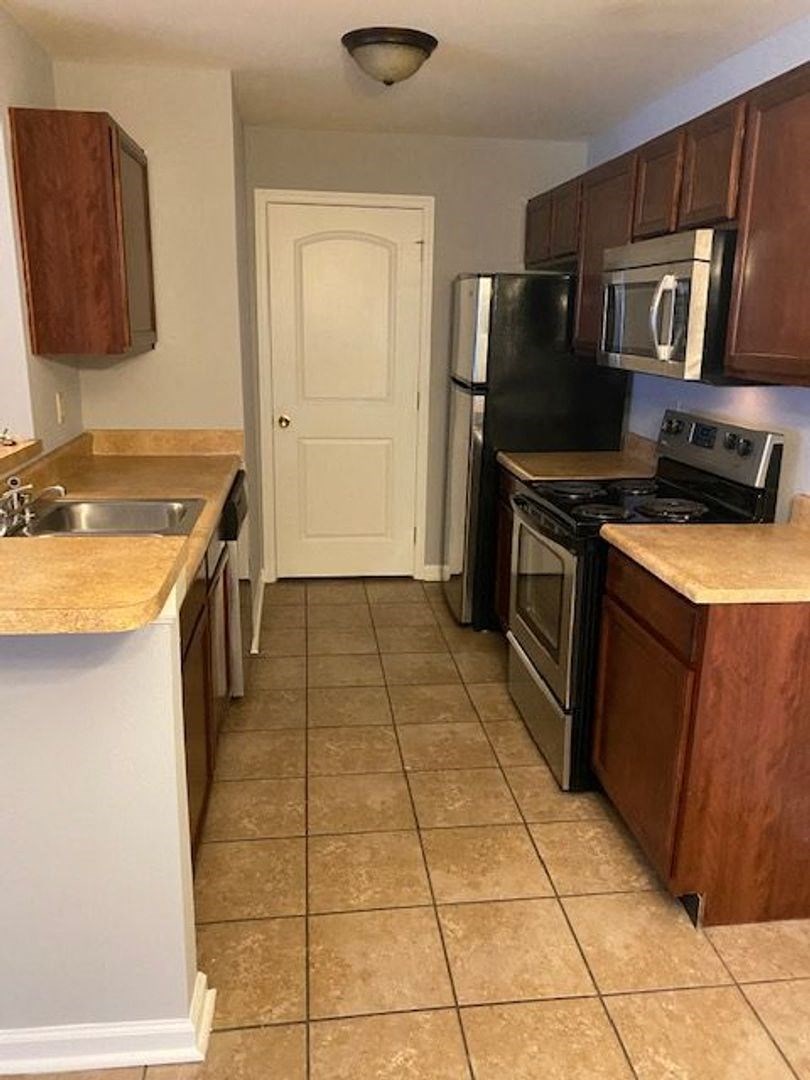 a kitchen with a stove refrigerator and a sink