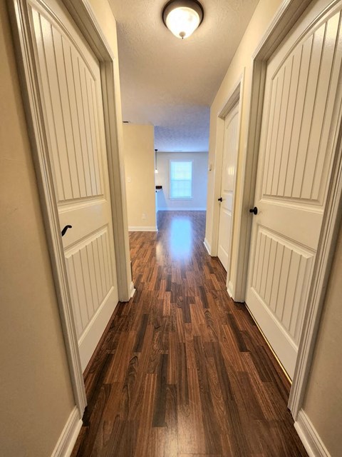 a hallway with wooden floors and white doors