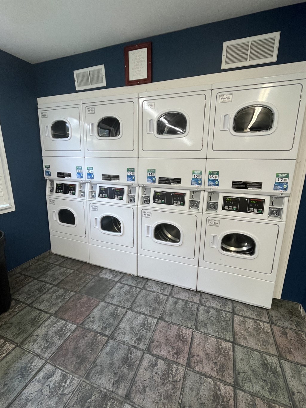 a row of washers and dryers in a laundry room
