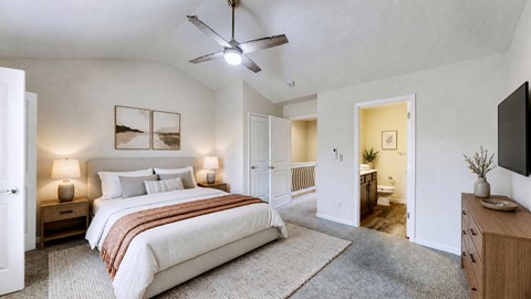 A bedroom with a large bed and a ceiling fan.