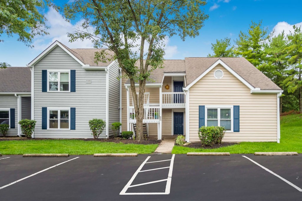 A two-story house with a parking lot in front.