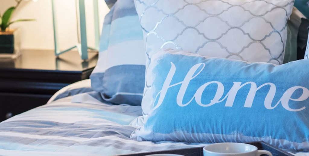 A blue pillow with the word "home" written on it.