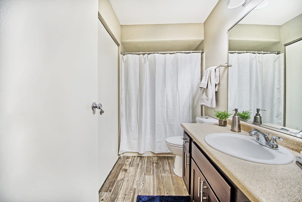 A bathroom with a white shower curtain and a white sink.