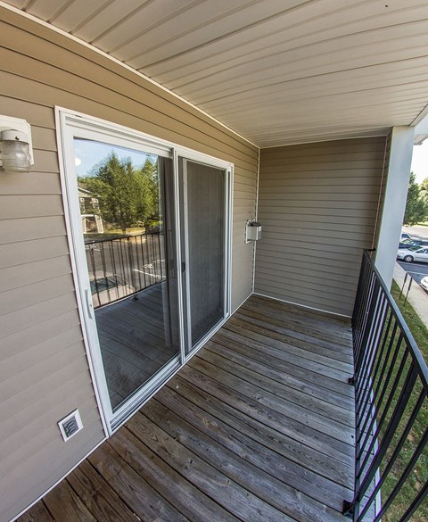 a covered porch with a sliding glass door and a deck