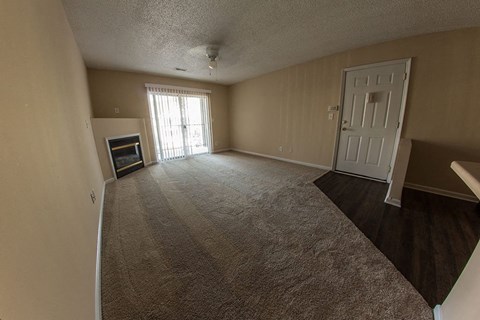 an empty living room with a fireplace and a white door