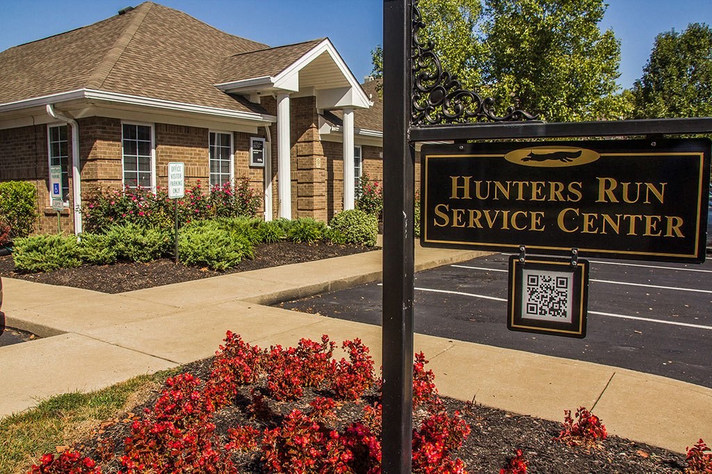 a hunters run service center sign in front of a house