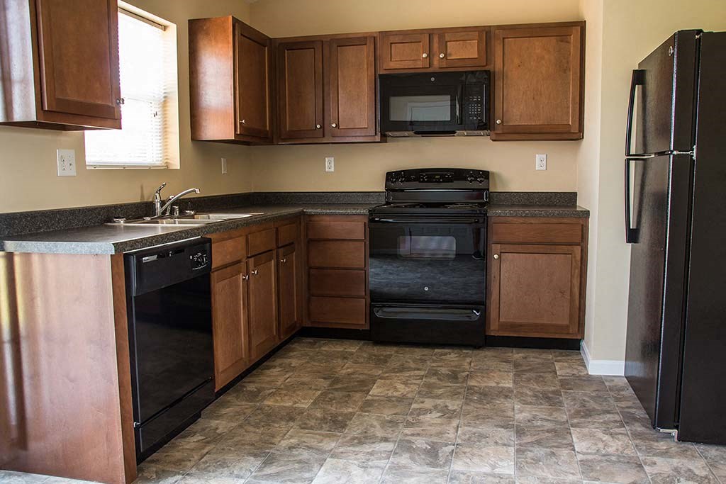 a kitchen with black appliances and wooden cabinets