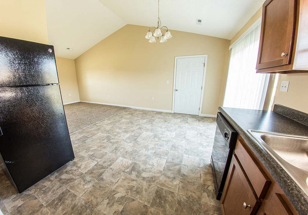 an empty kitchen with a refrigerator and a sink