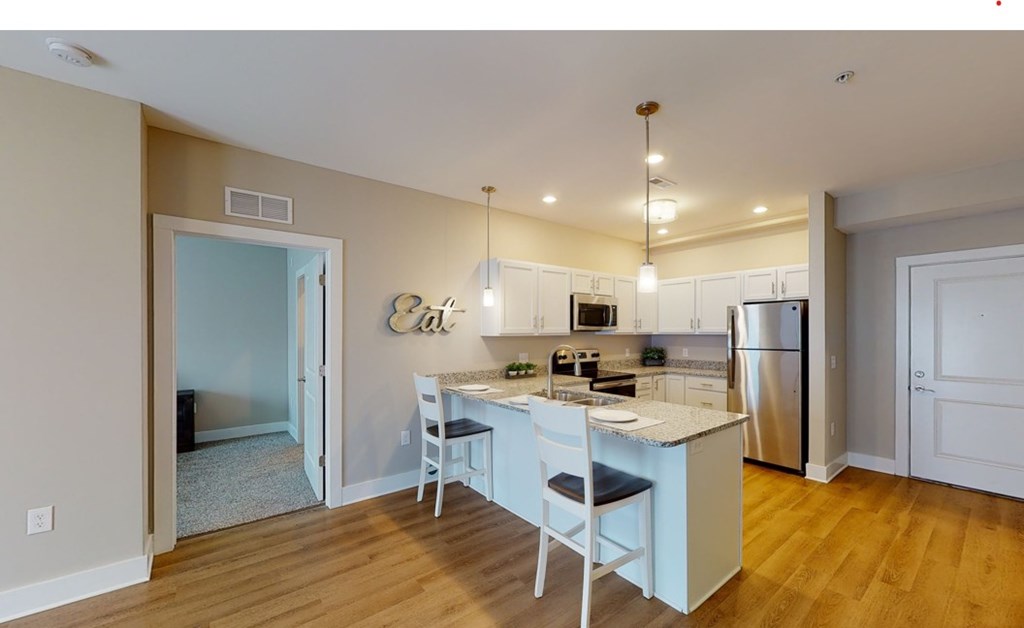 A kitchen with a table and chairs in the middle of the room.