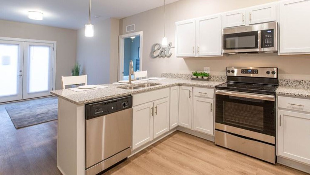 A kitchen with white cabinets and stainless steel appliances.