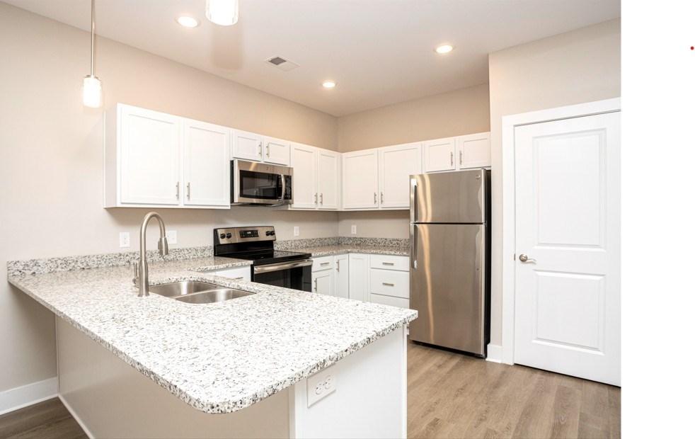 A kitchen with a granite countertop and stainless steel appliances.