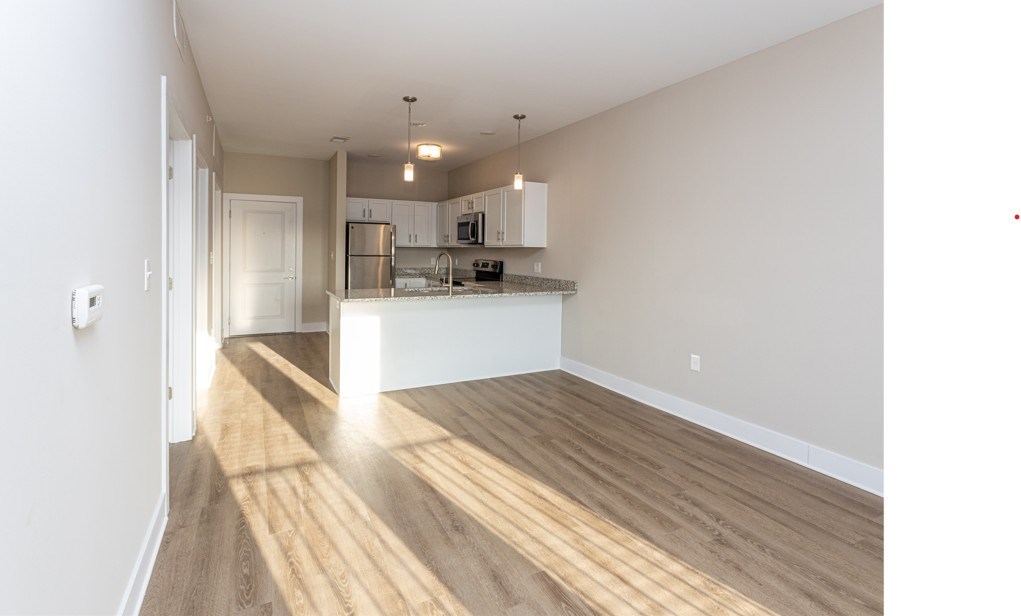 A kitchen with wooden floors and white walls.