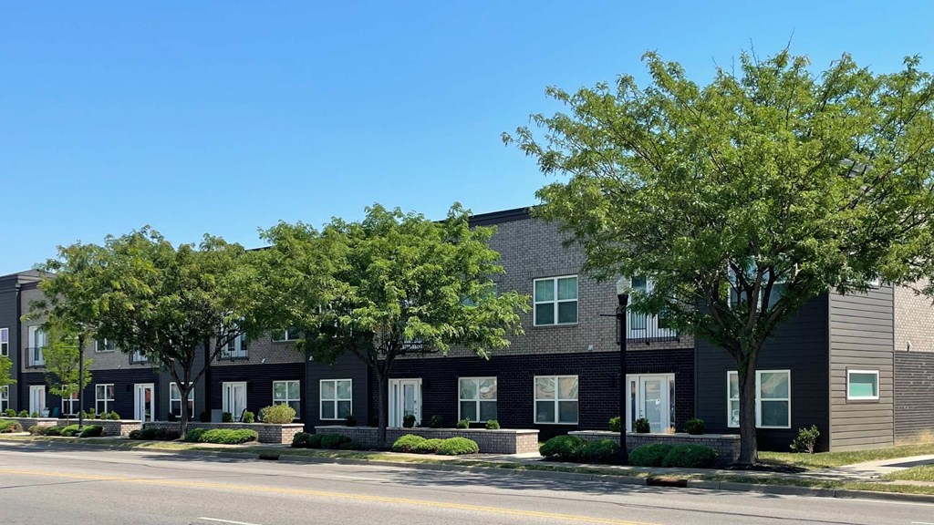 A row of houses with trees in front.