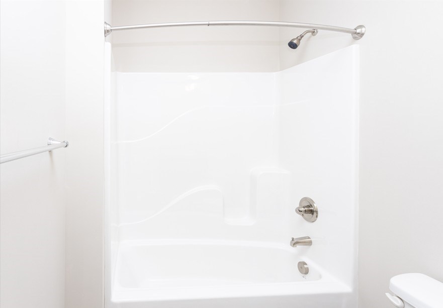 A white bathroom with a tub and toilet.