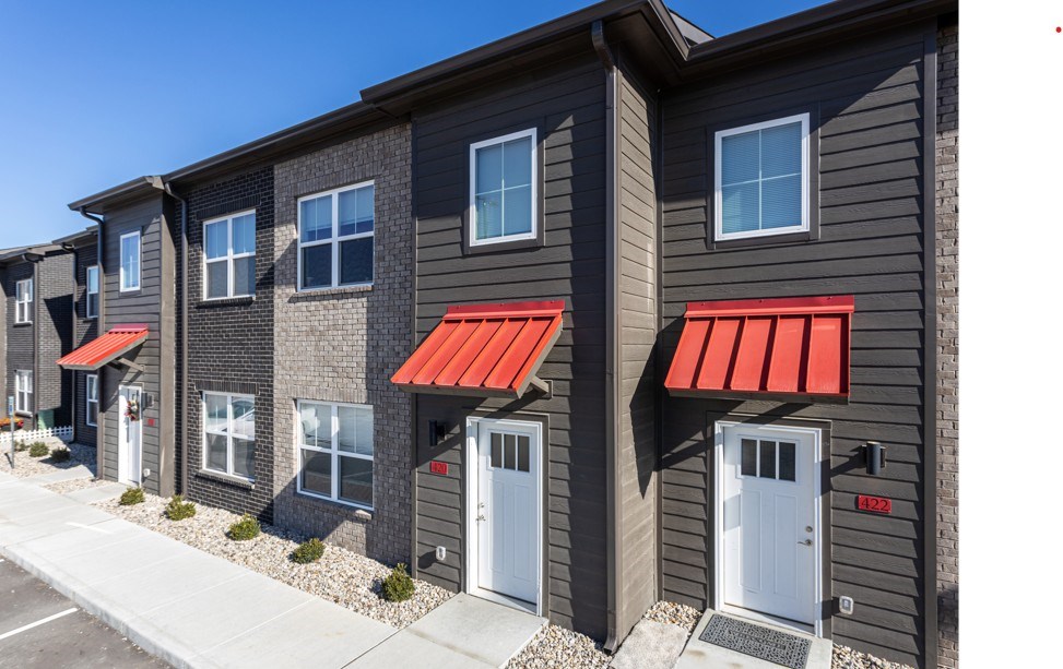 A row of houses with red awnings on the front.