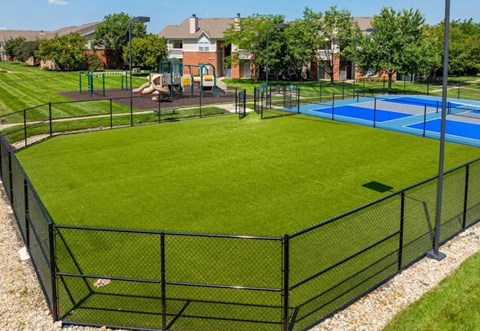 A black fenced in area with a blue pool in the middle.