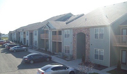 a row of houses with cars parked in front of them