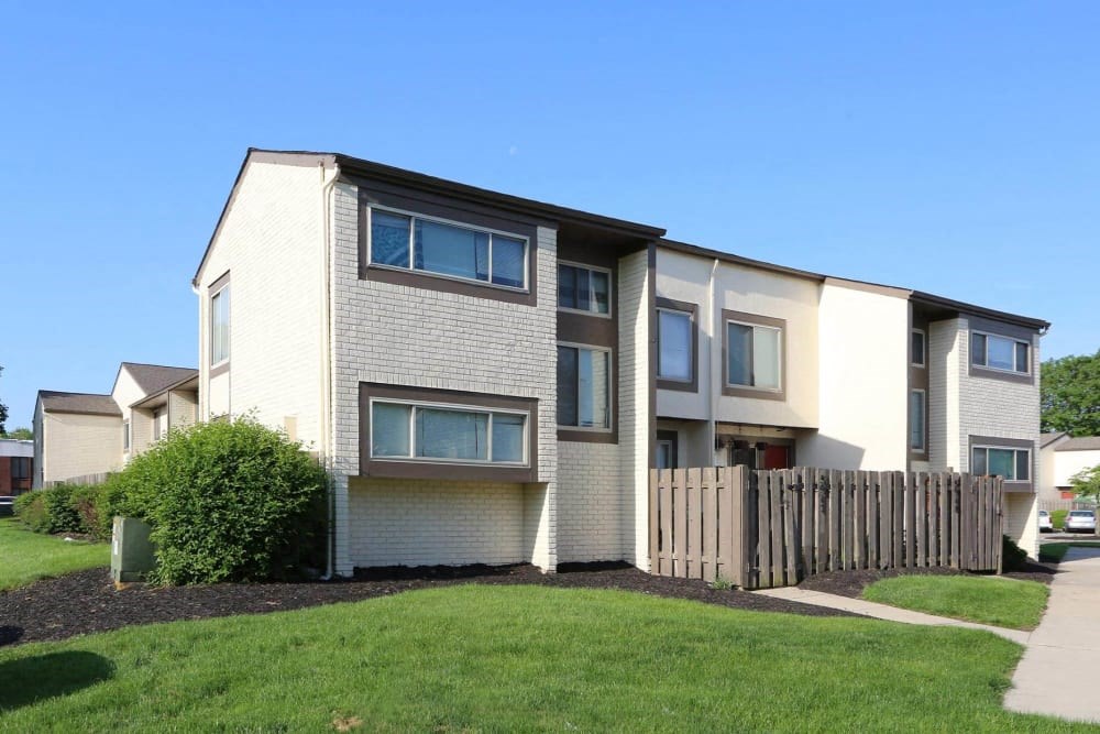an apartment building with a wooden fence in front of it