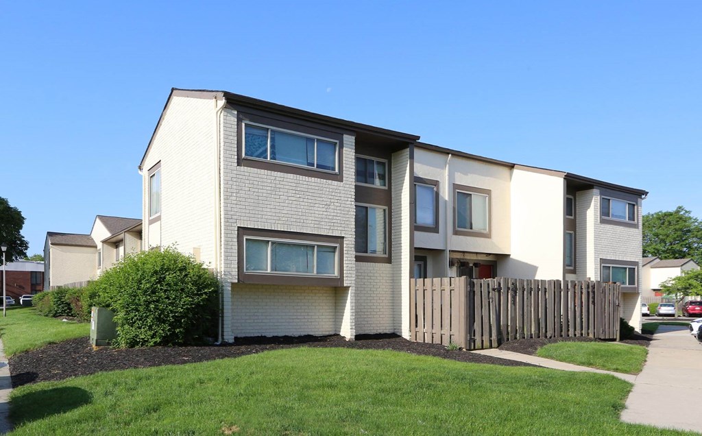 an apartment building with a wooden fence in front of it