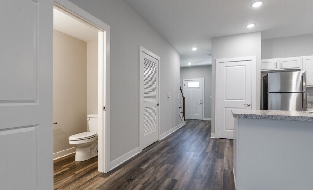 A modern kitchen with a wooden floor and white walls.
