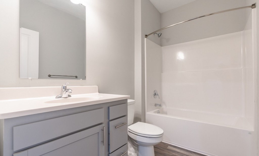 A white bathroom with a toilet, sink, and bathtub.