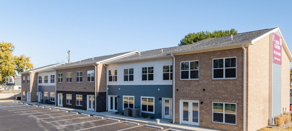 A large building with a parking lot in front.
