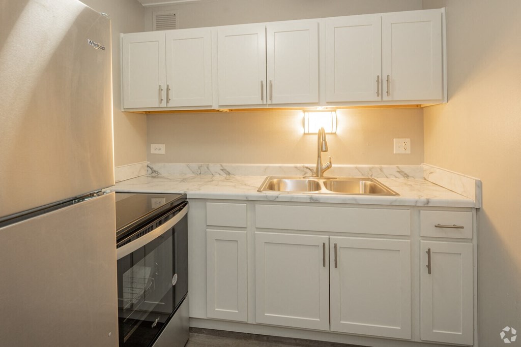 a kitchen with white cabinets and a stainless steel refrigerator