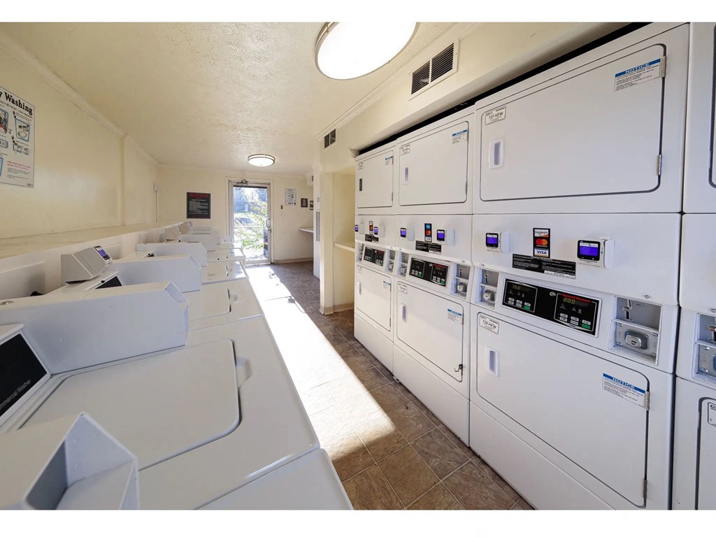 a laundry room with a row of washes and dryers