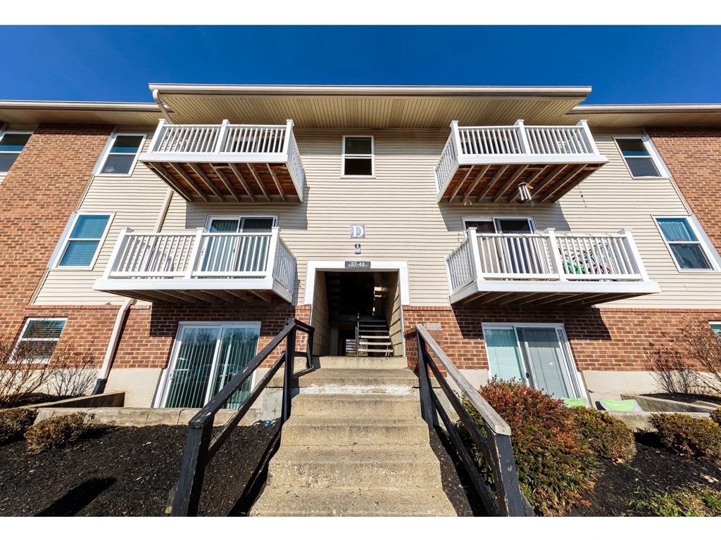 the front of a building with stairs and balconies