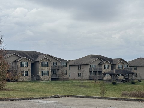 an apartment building on a hill with a cloudy sky