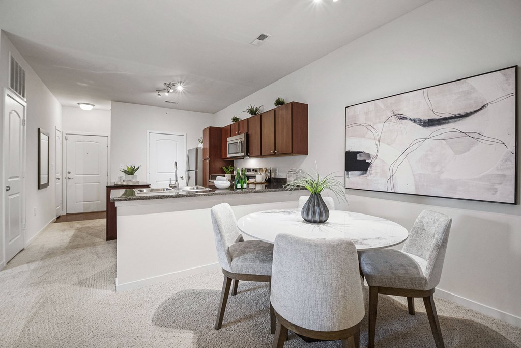 A modern kitchen with a dining table set for two. at Aventura at Richmond, St. Peters, 63376