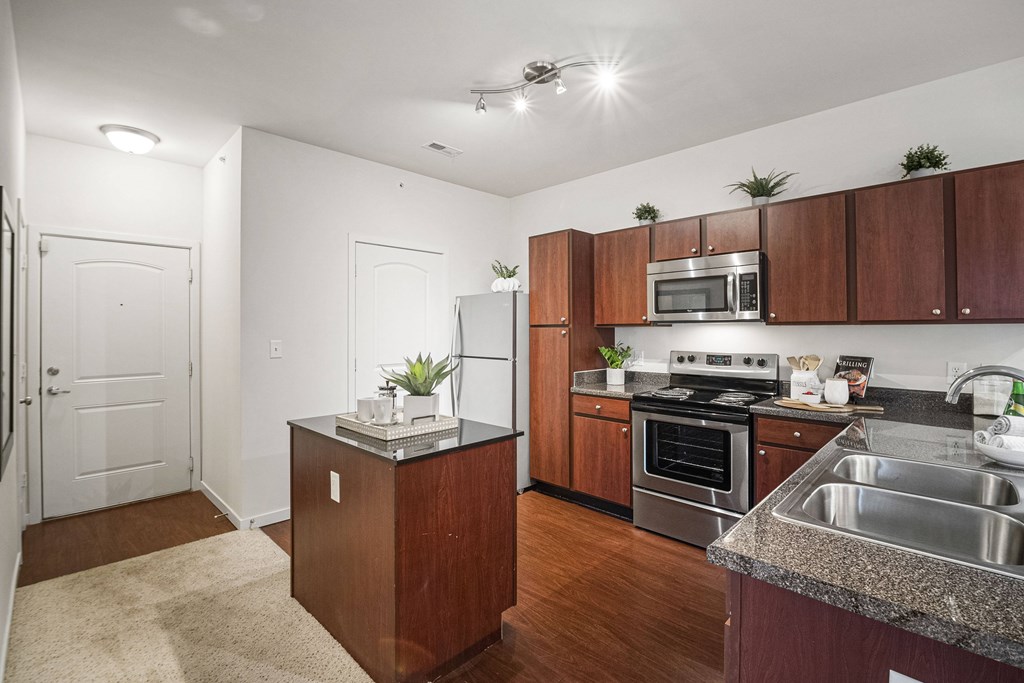 A kitchen with wooden cabinets and a granite countertop. at Aventura at Richmond, St. Peters, 63376