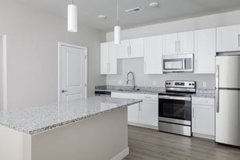 A kitchen with white cabinets and stainless steel appliances.