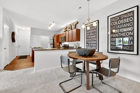 A modern kitchen with a dining table and chairs.