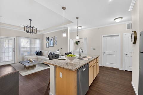 A modern kitchen with a granite countertop and a dining area with a table and chairs.