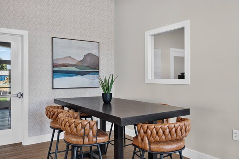 A dining table with four chairs and a potted plant.