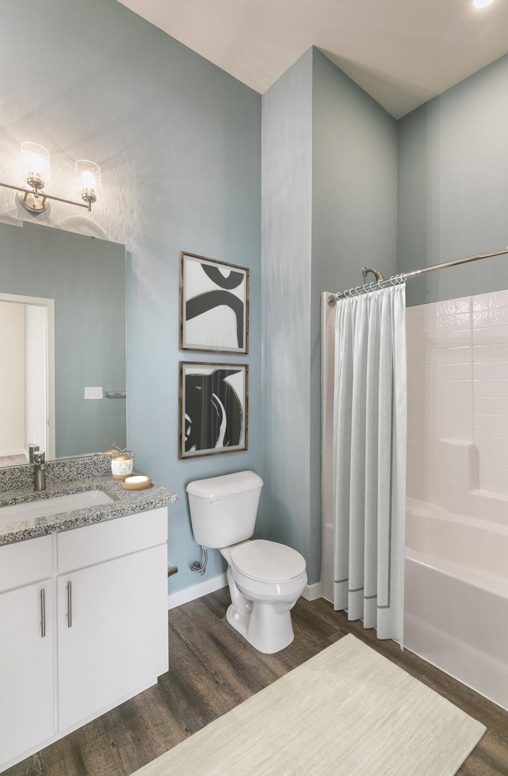A bathroom with a toilet, sink, and shower.
