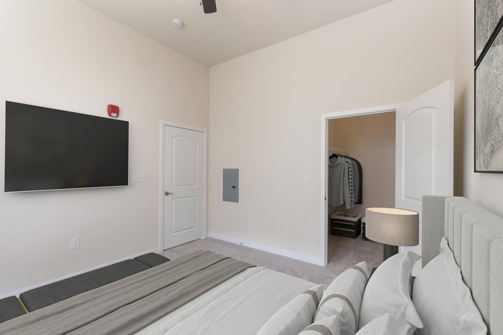 A living room with a grey sofa and a black television.