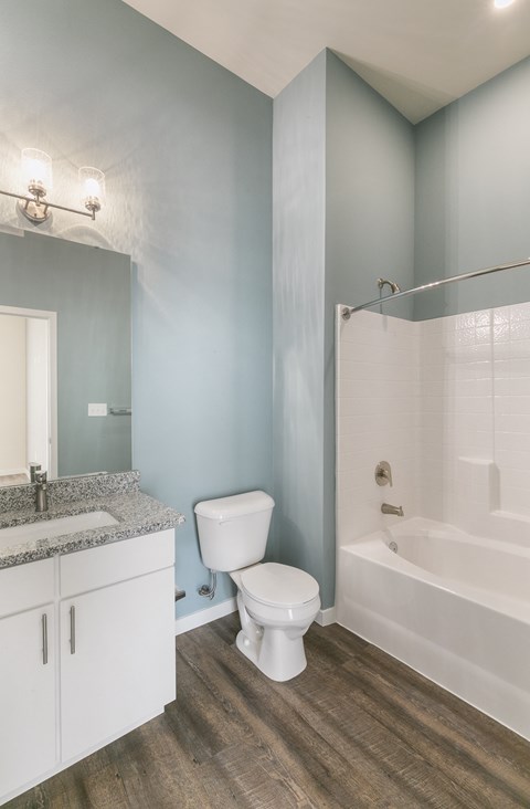 a bathroom with a toilet and a tub and a sink