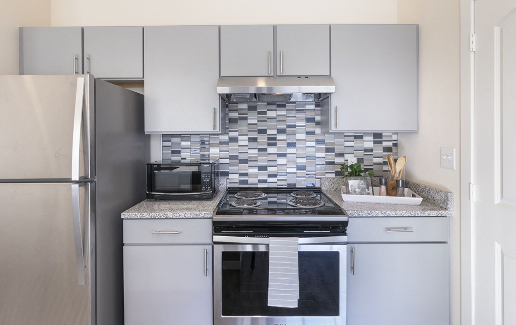 a kitchen with white cabinets and a stainless steel refrigerator