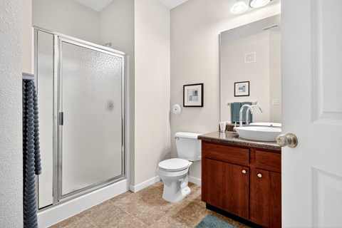 A bathroom with a toilet, sink, and shower.