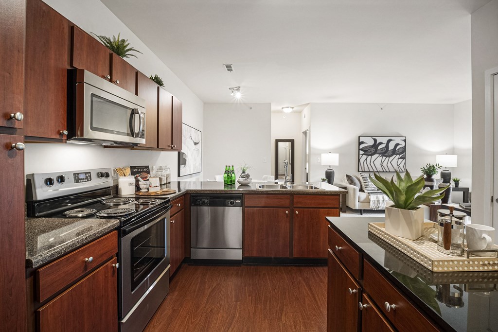 A kitchen with dark wood cabinets and a black counter top. at Aventura at Richmond, St. Peters, 63376