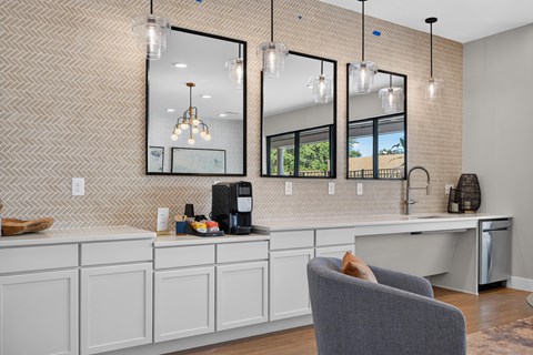 A modern kitchen with a grey chair and a coffee machine.