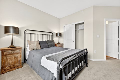 A bedroom with a bed, nightstand, and lamp.