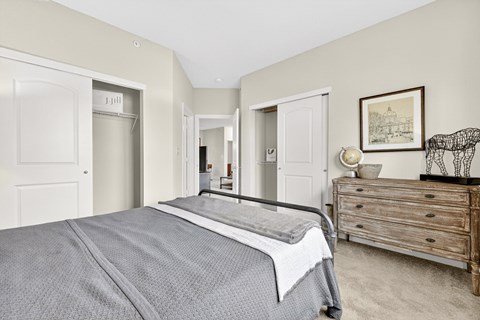 A bedroom with a bed, dresser, and mirror.